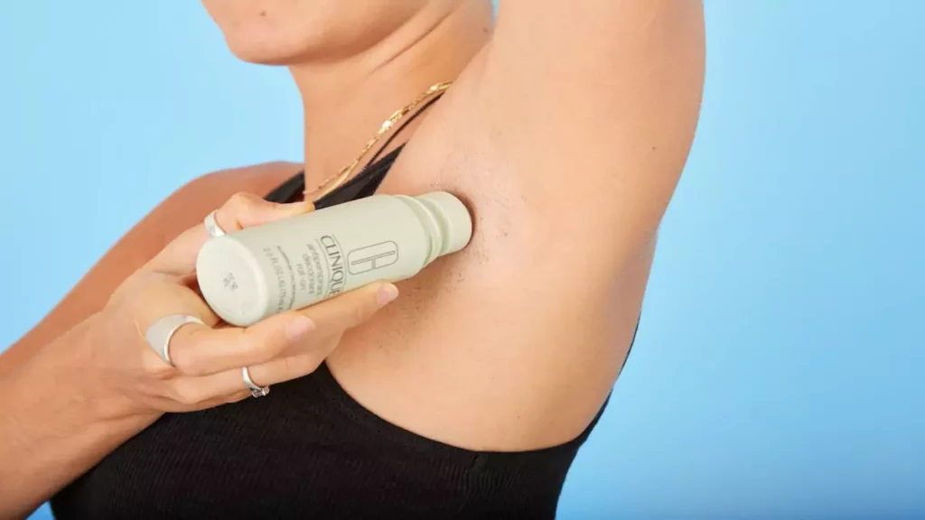 Mulher aplicando desodorante feminino em formato roll-on