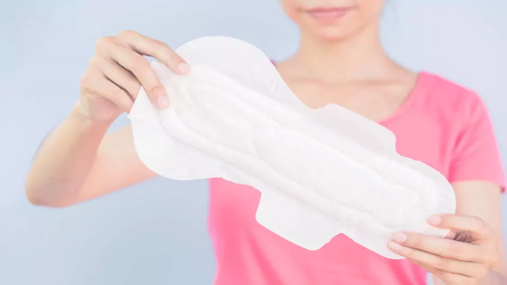 Mulher segurando um absorvente íntimo de frente