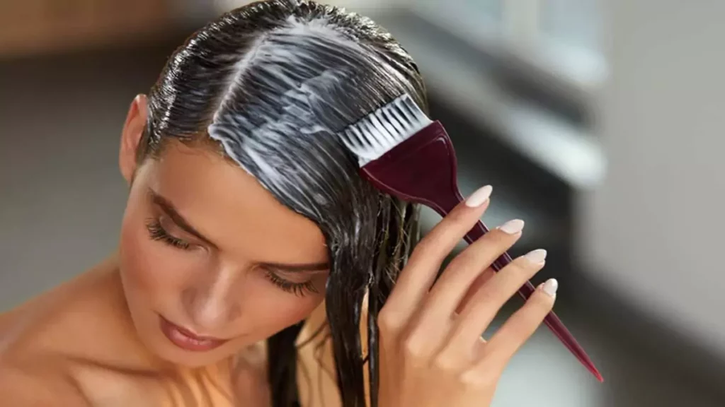 Mulher aplicando máscara de hidratação no cabelo durante o banho