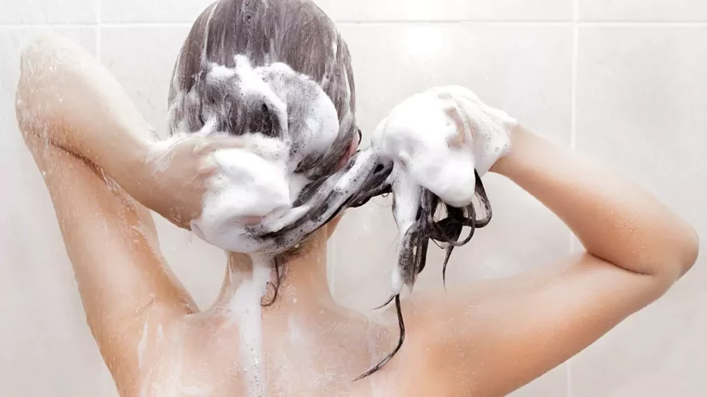 Mulher usando shampoo para cabelos oleosos durante o banho